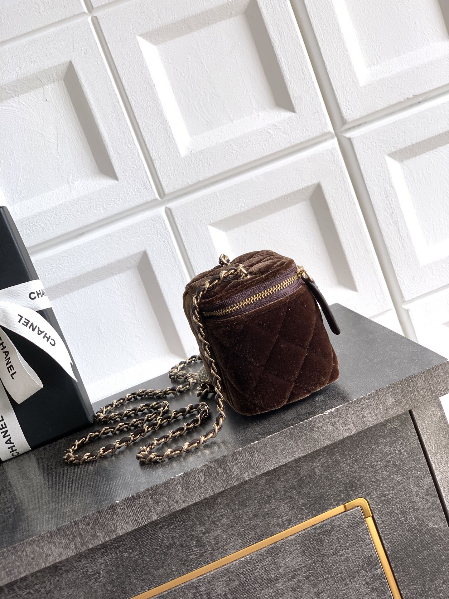 Quilted brown mini crossbody bag with gold-tone chain strap and zip closure