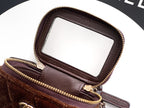 Brown zip-top mini bag with leather handle loop and gold-tone hardware