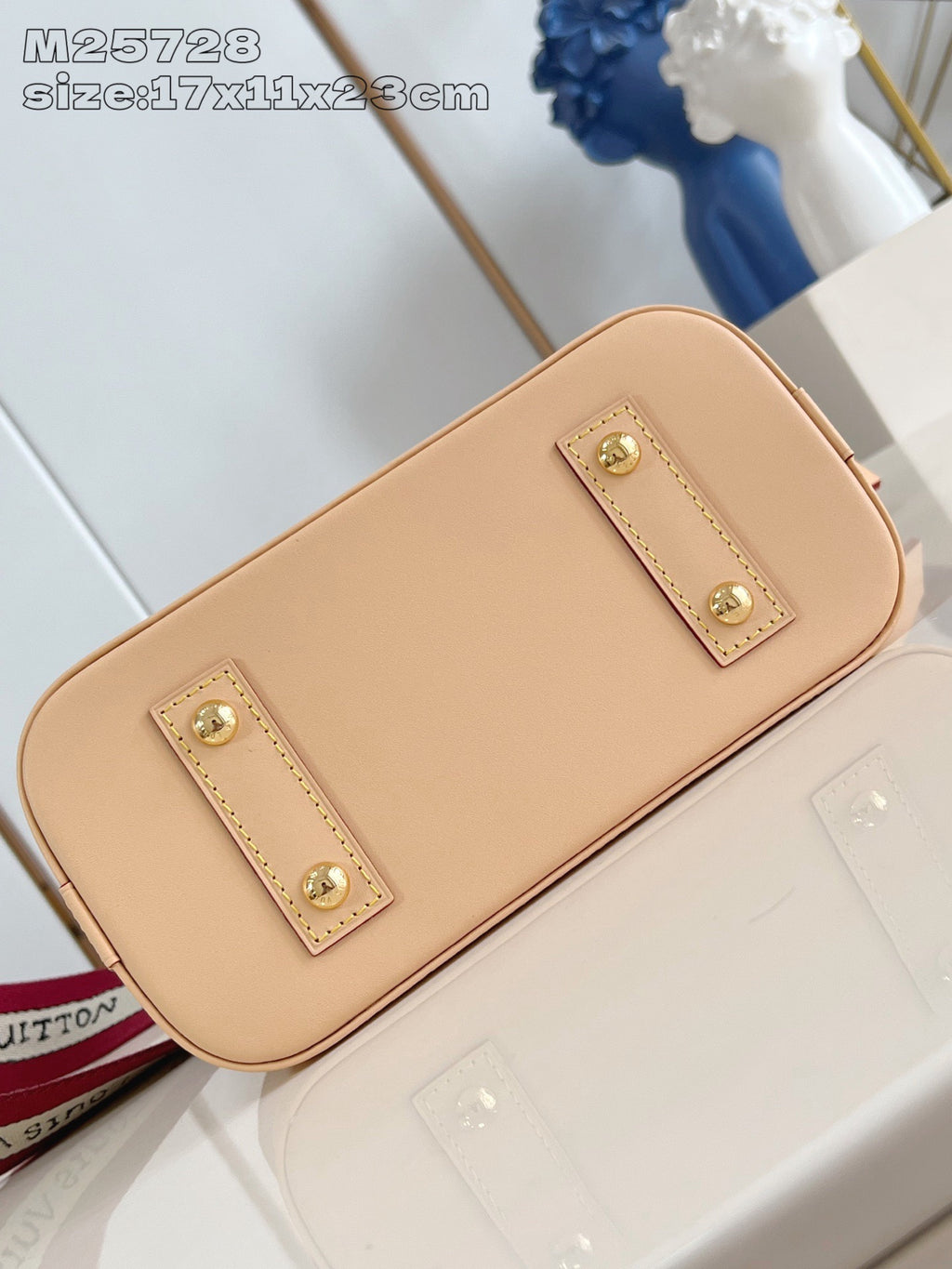 Mini tan leather bag with two gold-stud front tabs and smooth leather finish