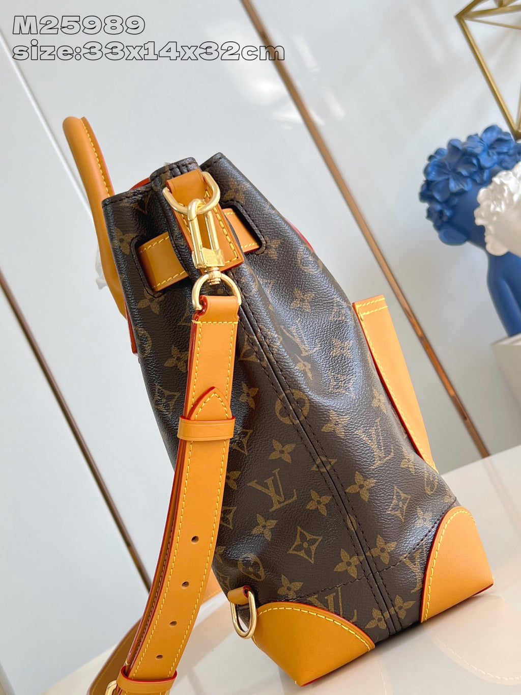 Louis Vuitton monogram handbag with tan shoulder strap and front zipper pocket detail