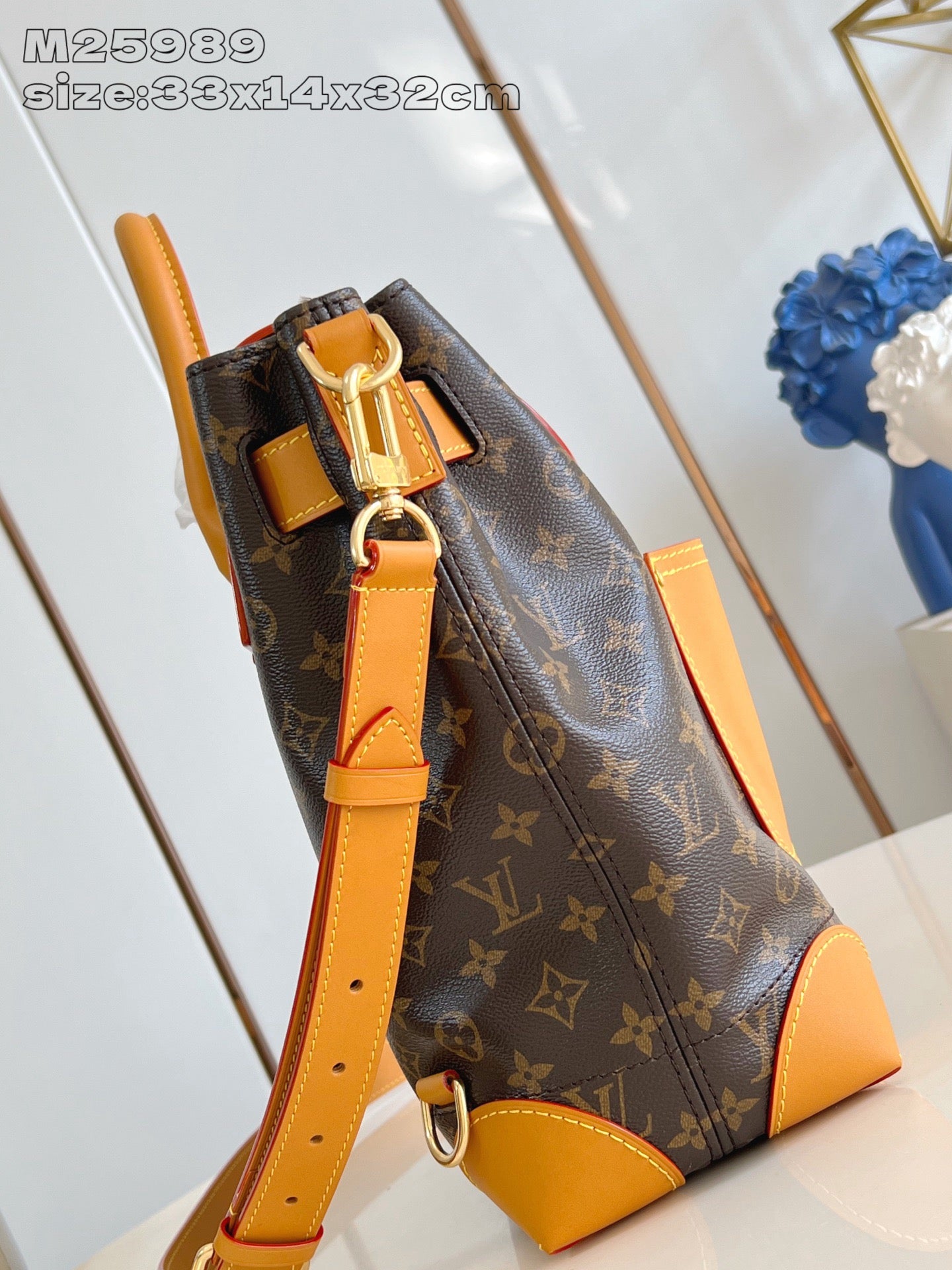 Louis Vuitton monogram handbag with tan shoulder strap and front zipper pocket detail