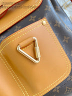 Louis Vuitton monogram handbag close-up: tan front pocket with stitched edges and metal clasp