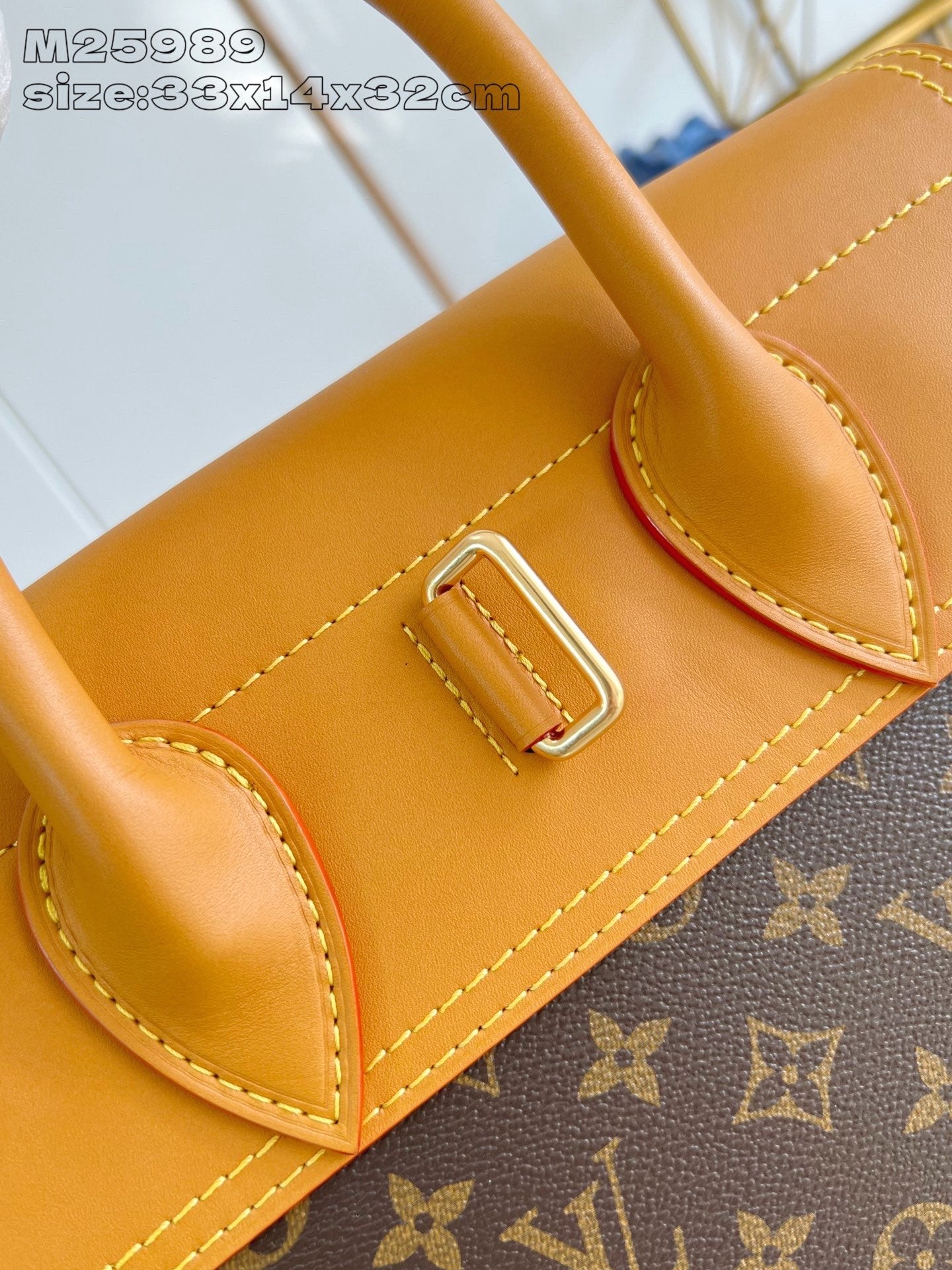 Louis Vuitton monogram handbag front corner pocket with tan leather panel and metal buckle