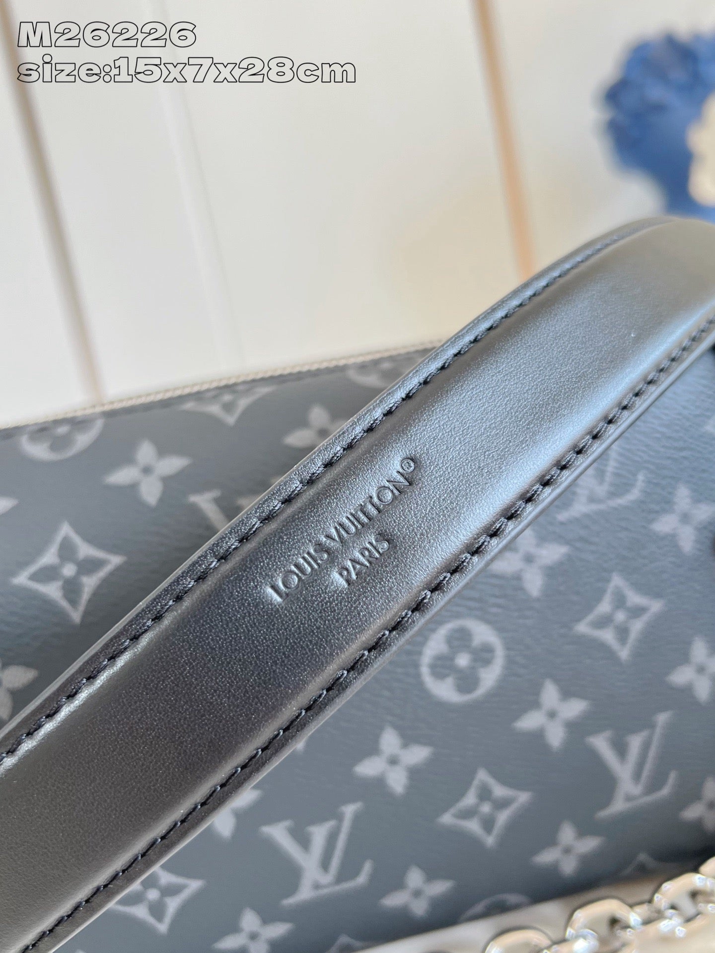 Crossbody bag strap detail with Louis Vuitton embossed logo on dark leather