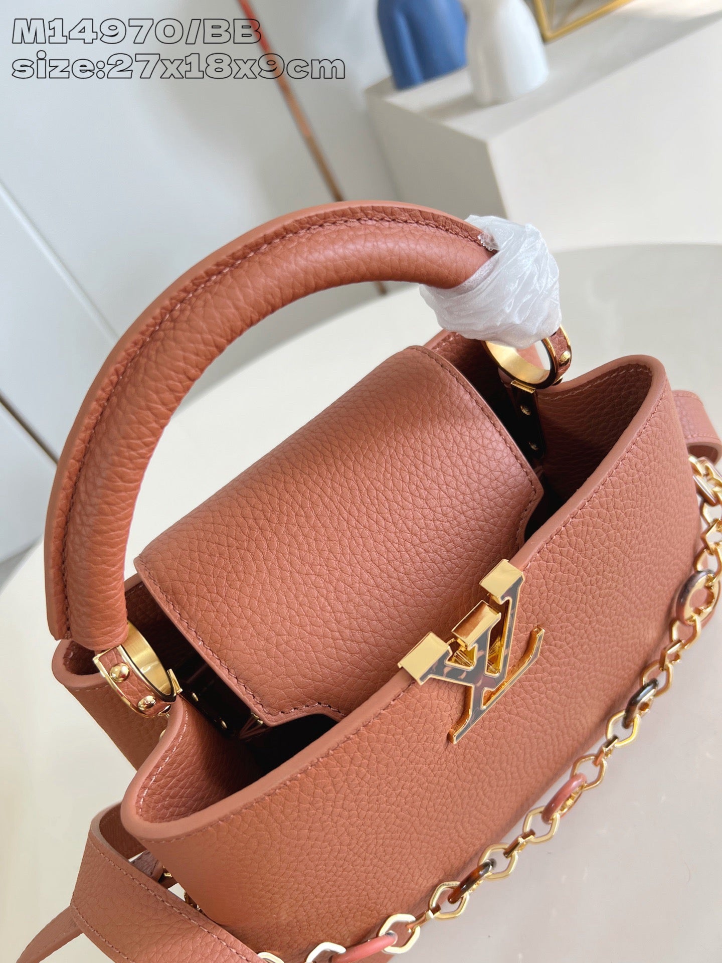 Pink pebbled leather mini bag with wrapped handle and gold chain detail