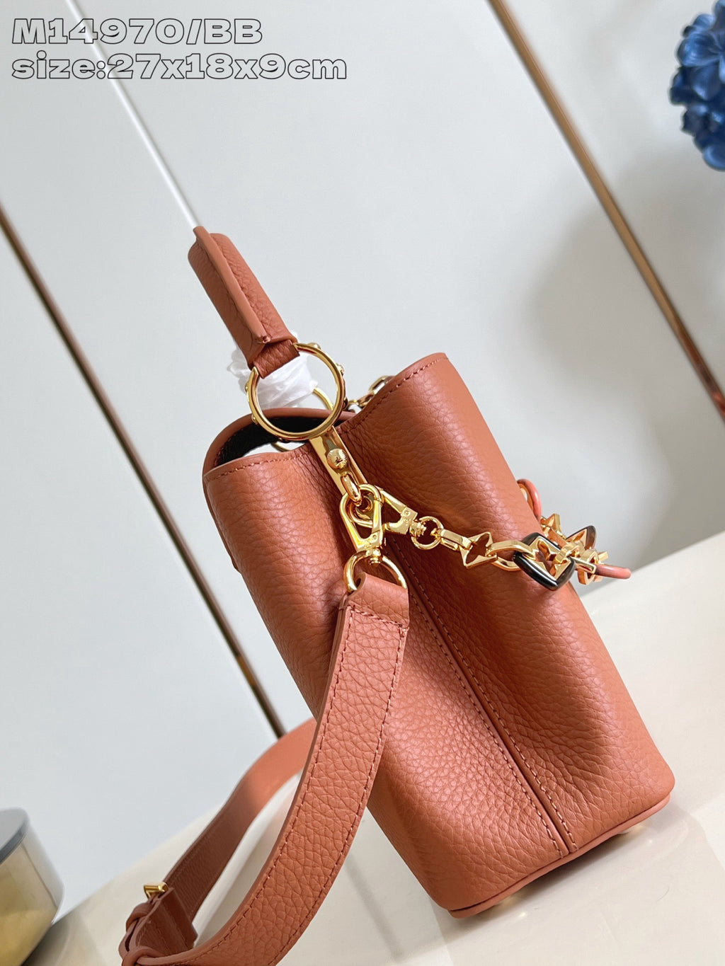 Pink pebbled leather handbag with crossbody strap and gold ring hardware