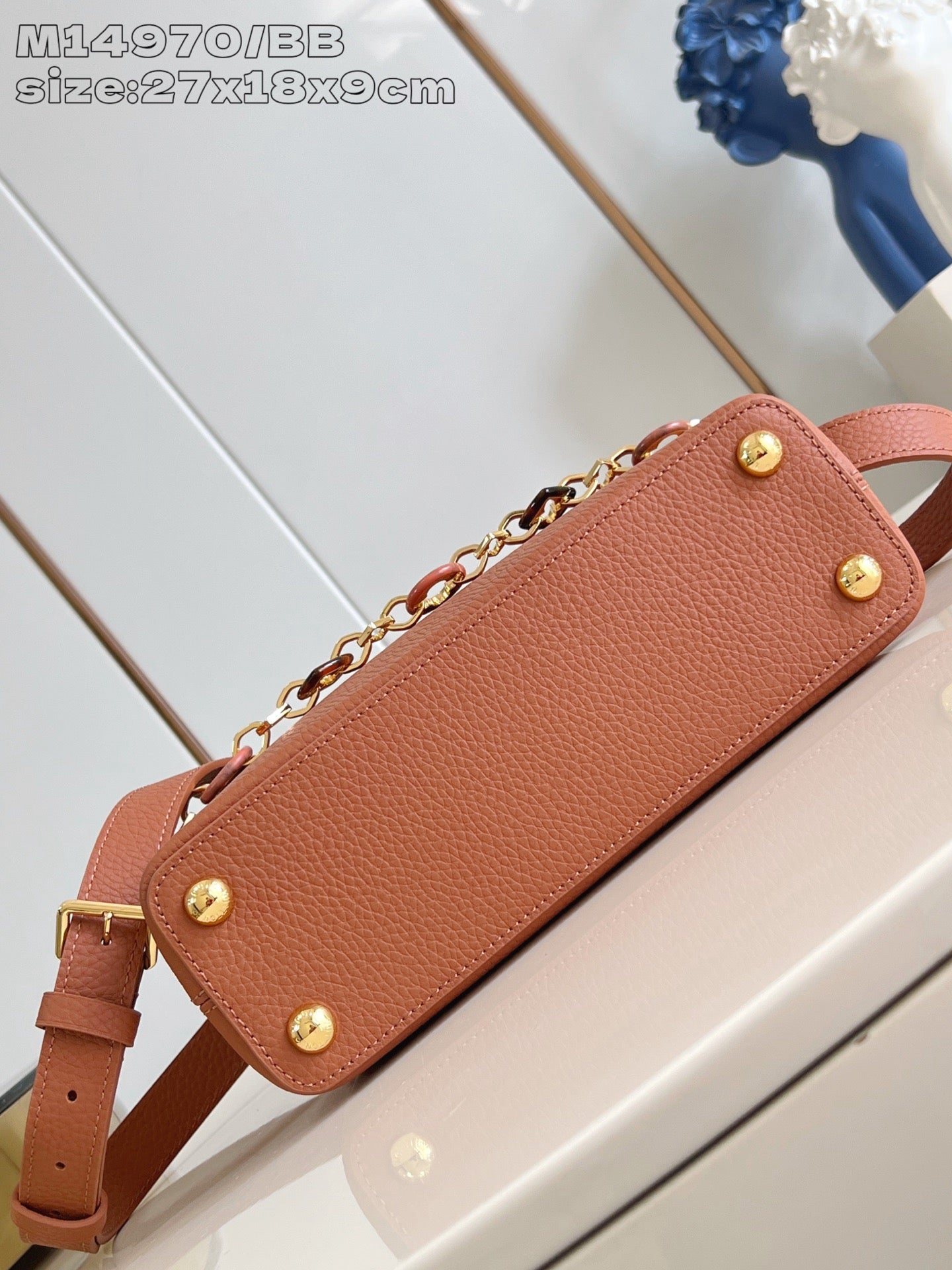 Pink pebbled leather handbag with gold button feet and chain strap