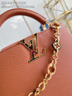 Front LV emblem and gold chain on pink pebbled leather handbag