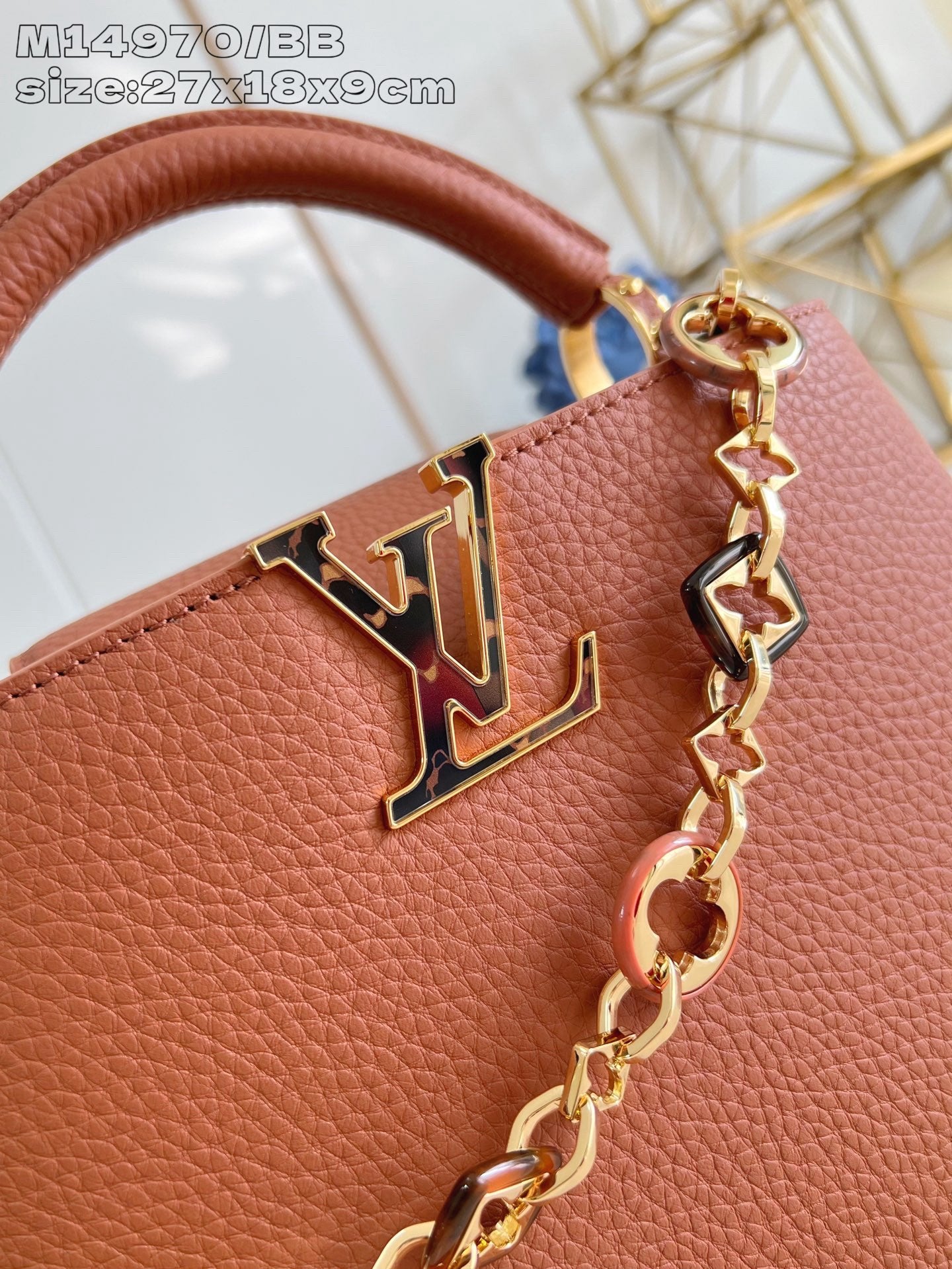 Front LV emblem and gold chain on pink pebbled leather handbag