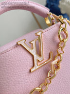 Louis Vuitton mini handbag close-up with gold LV emblem on light pink leather