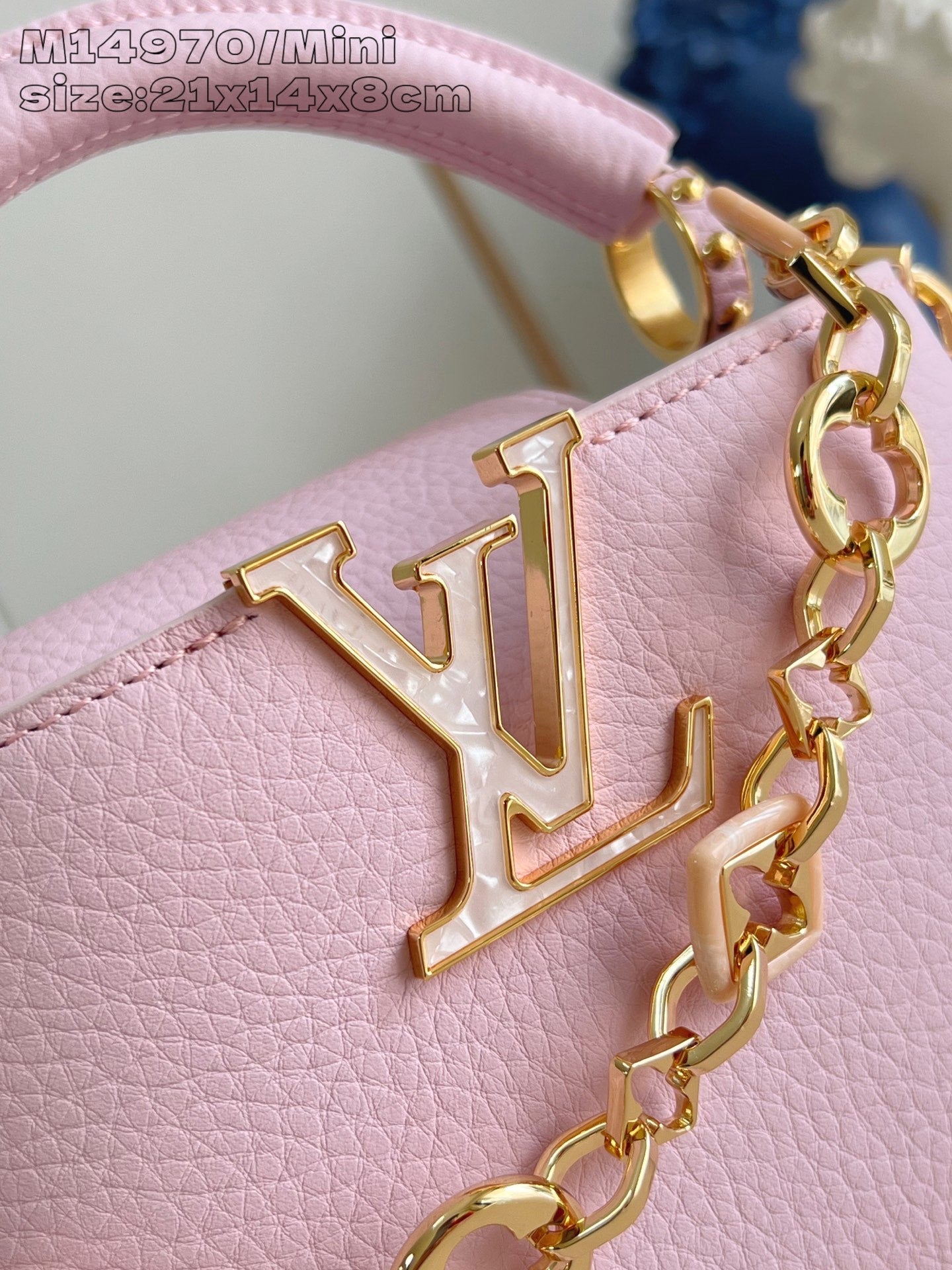 Louis Vuitton mini handbag close-up with gold LV emblem on light pink leather