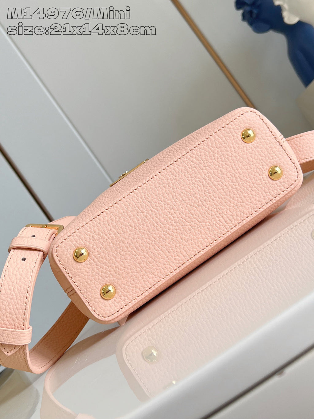 Louis Vuitton mini handbag exterior, pink textured body with gold stud feet