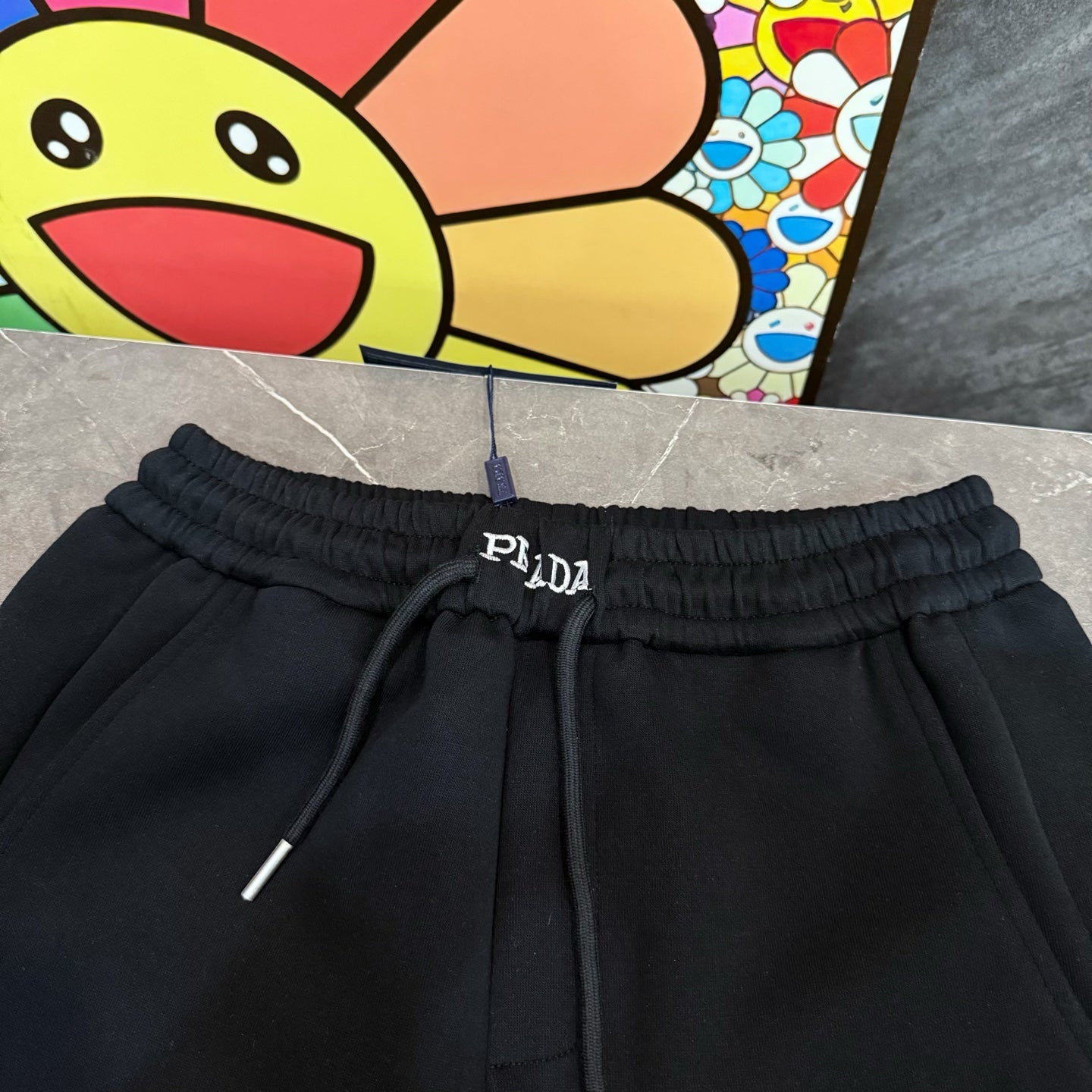 Black Prada pants waistband with drawstring cords and PRADA logo at front.