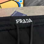 Black Prada pants with PRADA label on waistband and black drawstring.