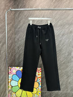 Black Prada pants with elastic waistband and drawstring, side logo detail.