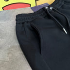 Black Prada pants with elastic waistband and front drawstring cords.