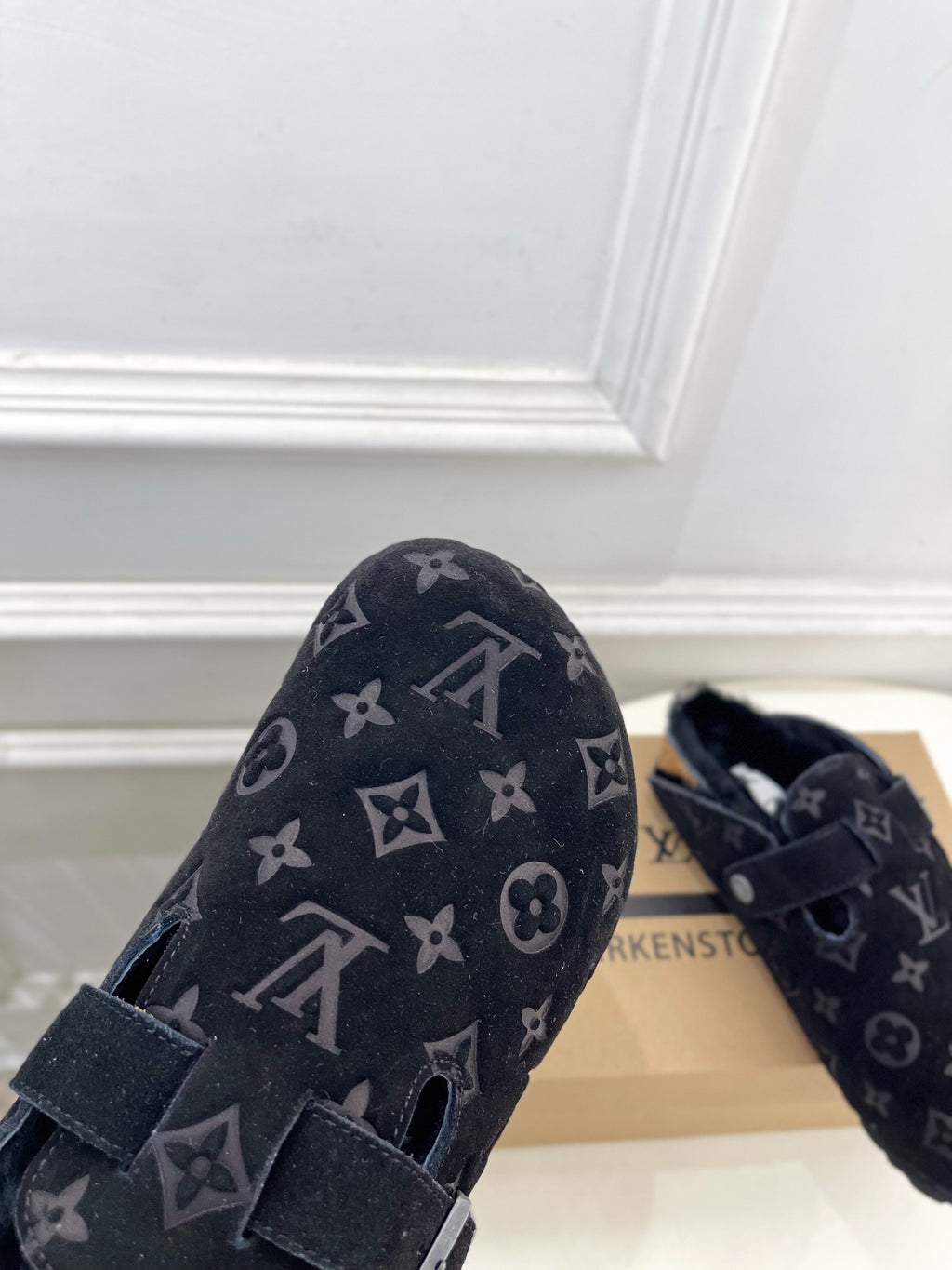 Dark monogram slide sandal with two strap closures and silver-toned buckle.