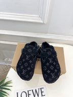 Louis Vuitton monogram slide sandals with dark buckle straps, plush footbed.
