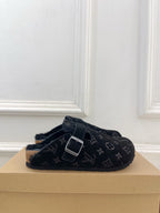 Monogram slide sandal in dark fabric with adjustable buckle strap and open toe.