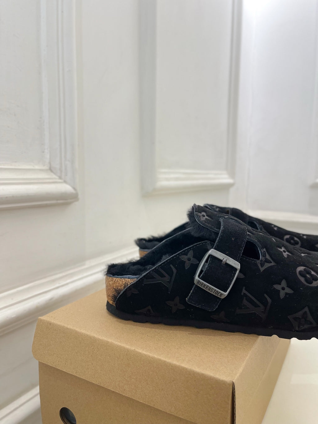 Dark monogram slide sandal with single adjustable buckle strap and textured outsole.