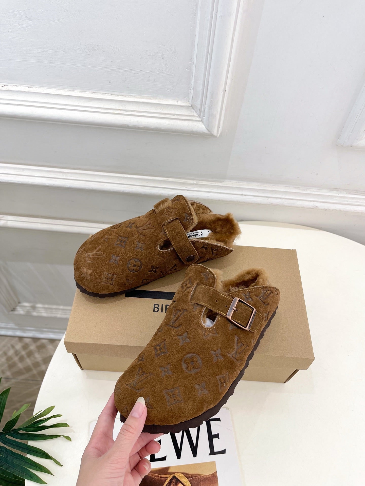 Brown suede clogs with adjustable buckle strap and fluffy shearling lining