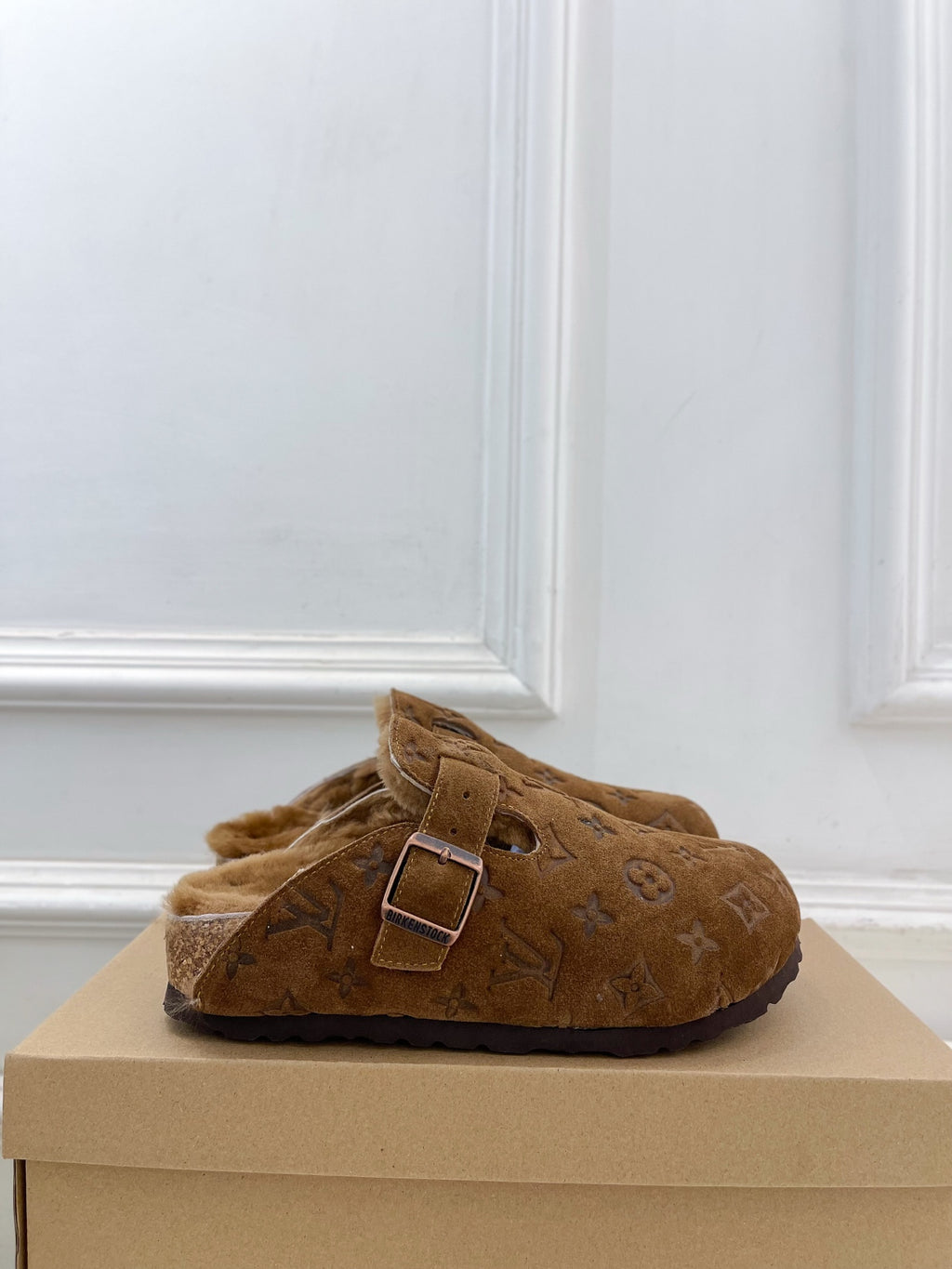 Brown suede slide sandals with adjustable buckle strap and shearling lining