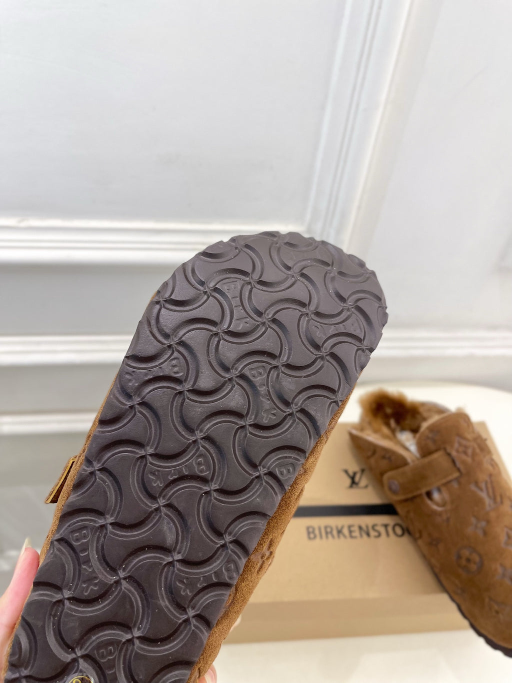 Brown suede sandal outsole with textured tread and buckle strap, sole close-up