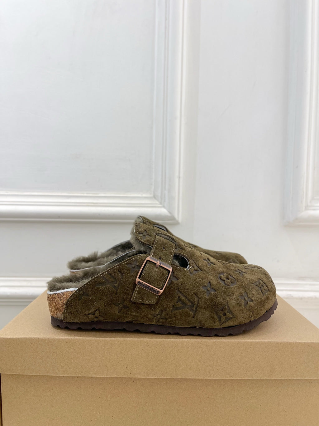 Olive green monogram slide sandal with buckle strap and shearling lining