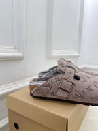 Monogram slide sandals in dark taupe suede with adjustable strap and buckle, plush lining