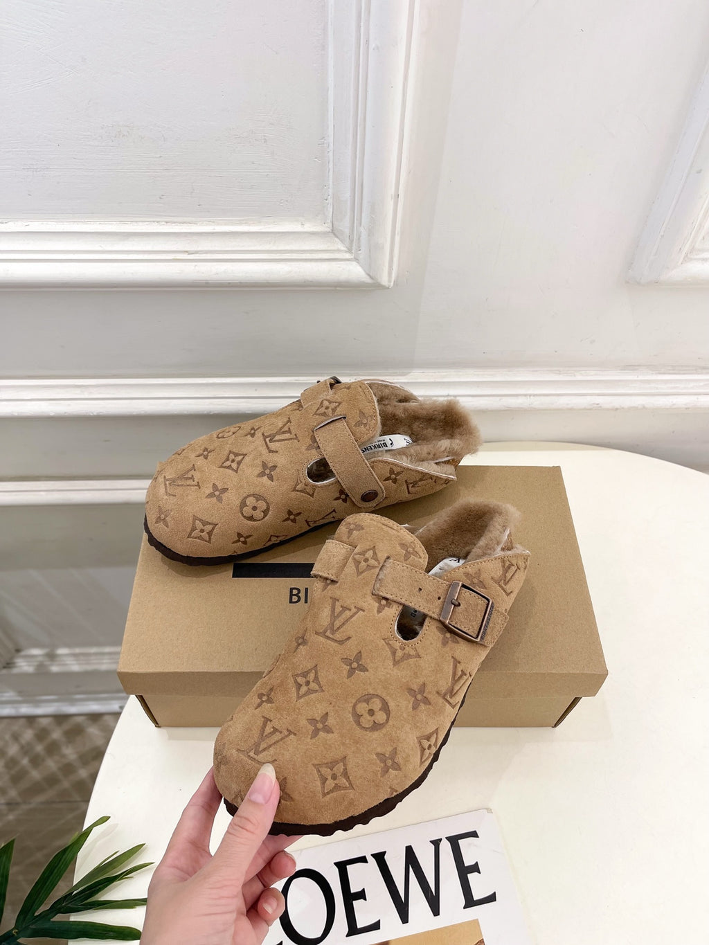 Tan Louis Vuitton monogram shearling slide sandals with two-buckle strap across the foot