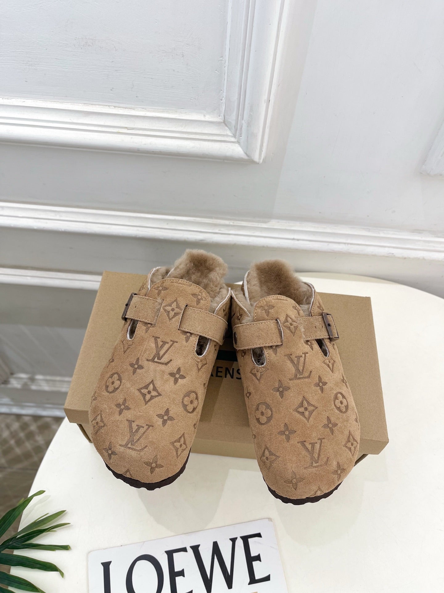 Tan Louis Vuitton monogram slide sandals with adjustable buckle strap and plush shearling