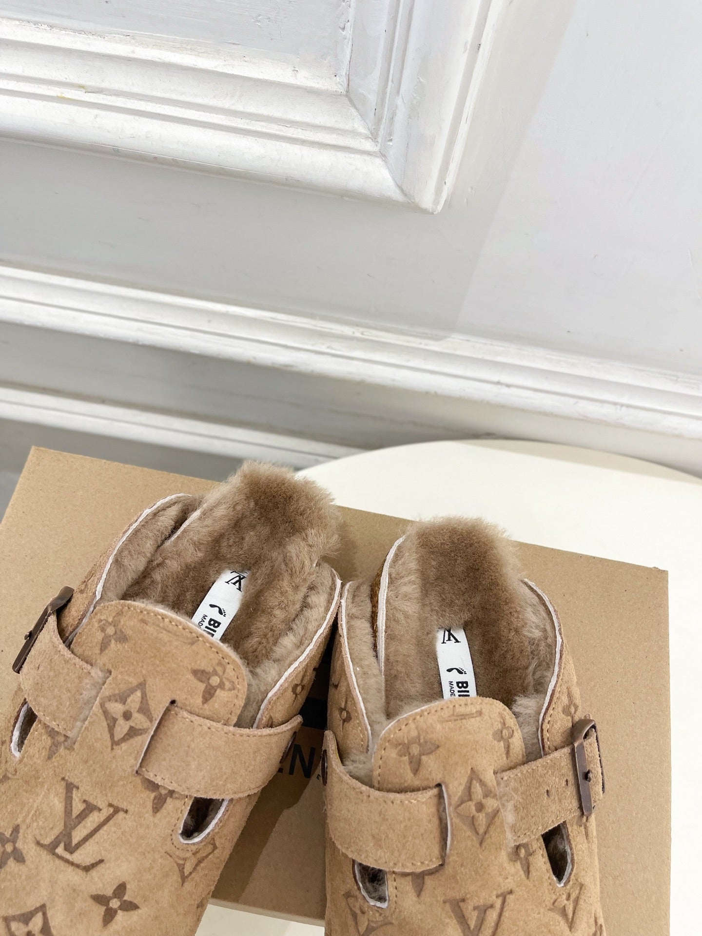 Tan Louis Vuitton monogram shearling slide sandals with two straps and buckle details
