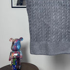 Long puffer jacket lower back hem in gray cable-knit with ribbed edge.