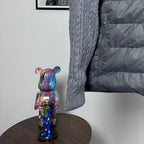 Long puffer jacket side view with gray knit sleeve and dark quilted body panel.