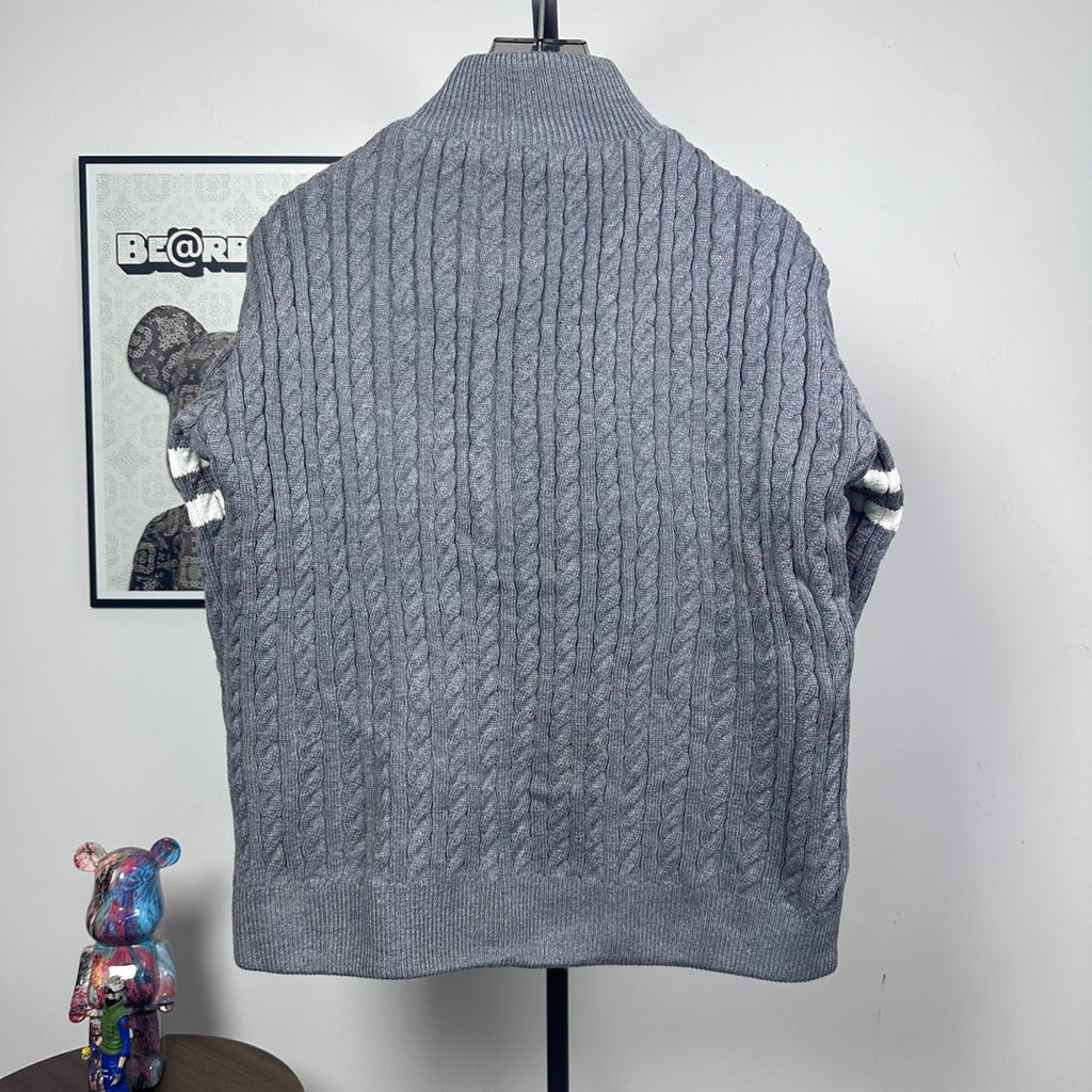 Long puffer jacket back view with gray cable-knit texture and stand collar.
