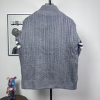 Long puffer jacket back view with gray cable-knit texture and stand collar.
