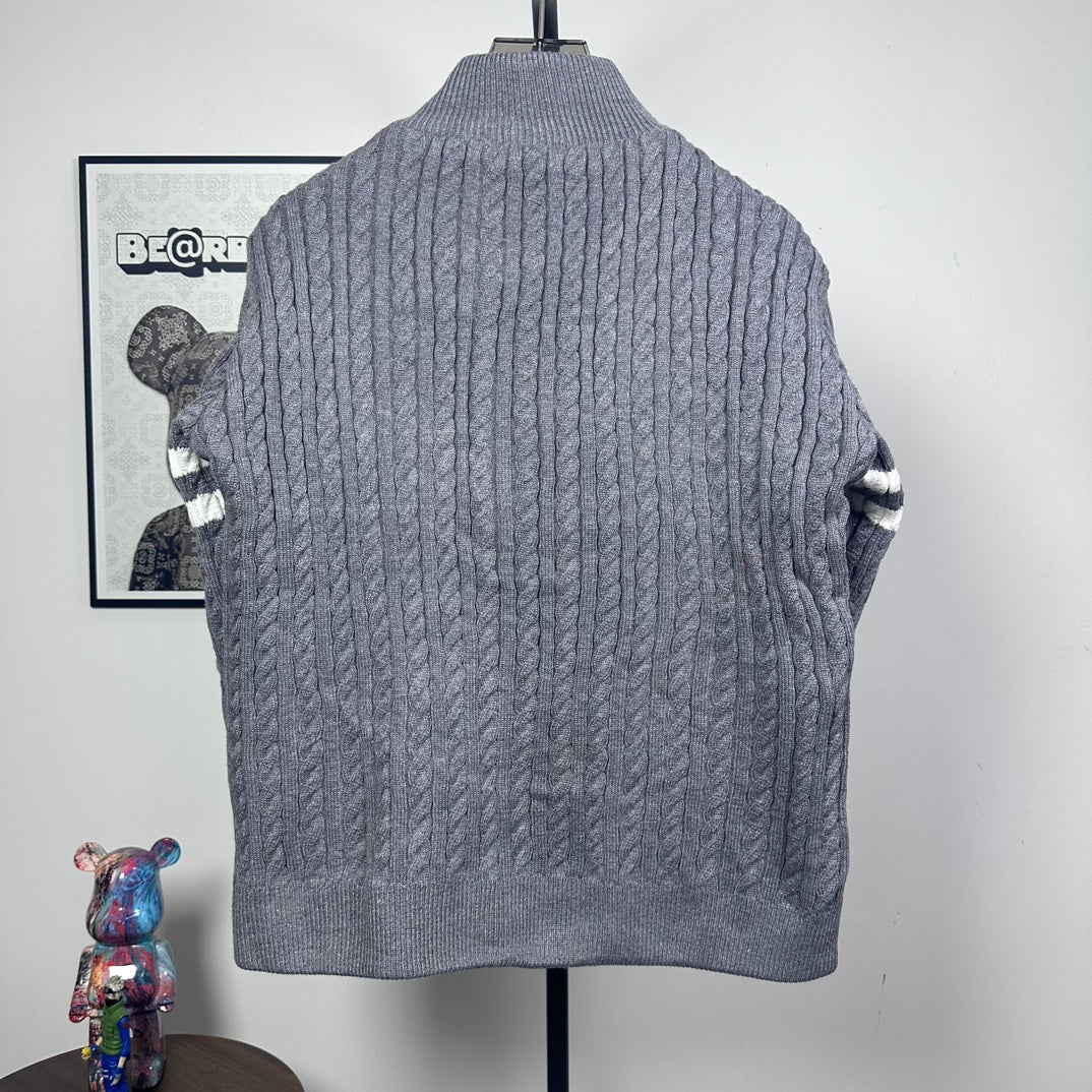 Long puffer jacket back view with gray cable-knit texture and stand collar.