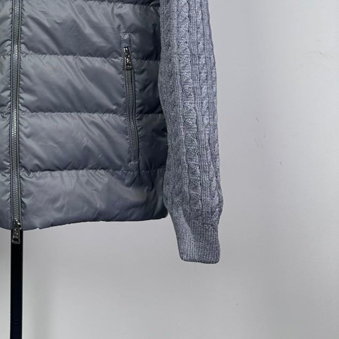 Long puffer jacket quilted dark body panel with zipper and seam detail.