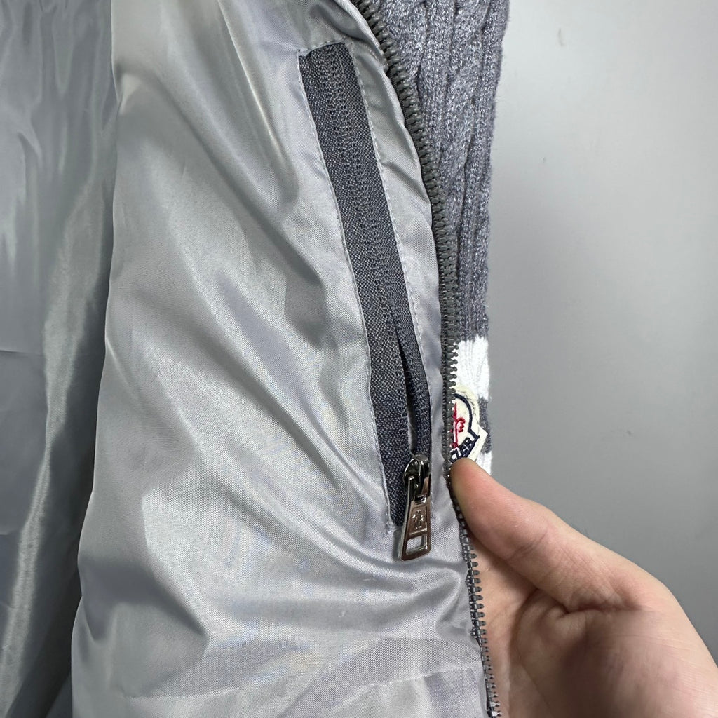 Long puffer jacket with metal zipper close-up and fabric panel detail