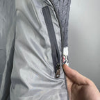 Long puffer jacket with metal zipper close-up and fabric panel detail