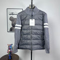 Long puffer jacket with stand collar, full zip, gray knit sleeves and striped cuffs.