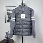 Long puffer jacket with stand collar, full zip, gray knit sleeves and striped cuffs.