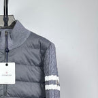 Long puffer jacket front shoulder detail with full zip and gray knit sleeve.