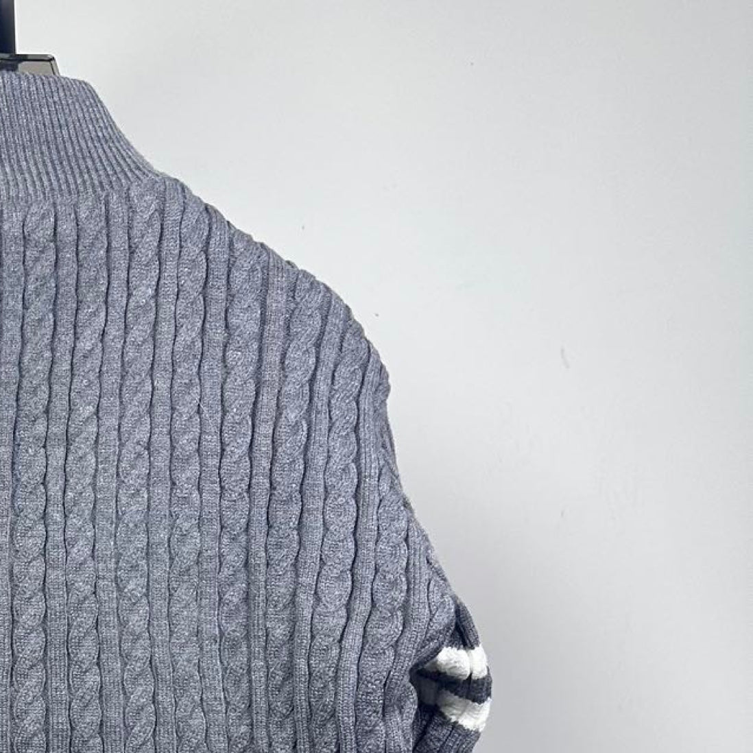 Long puffer jacket back upper knit with ribbed stand collar and cable pattern.