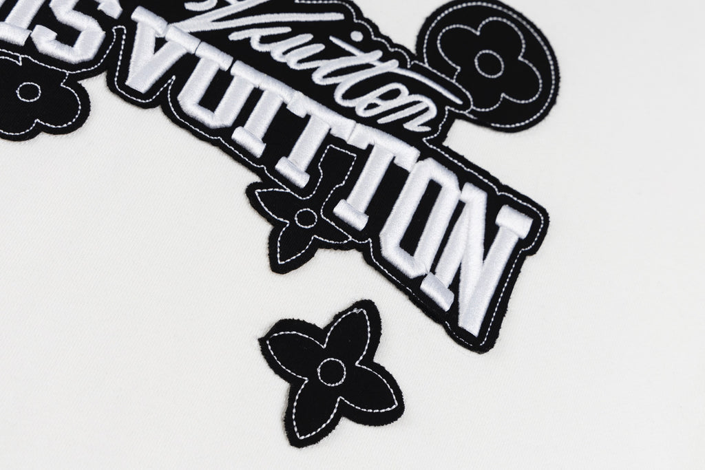 White long-sleeve sweatshirt logo close-up with outlined Louis Vuitton text