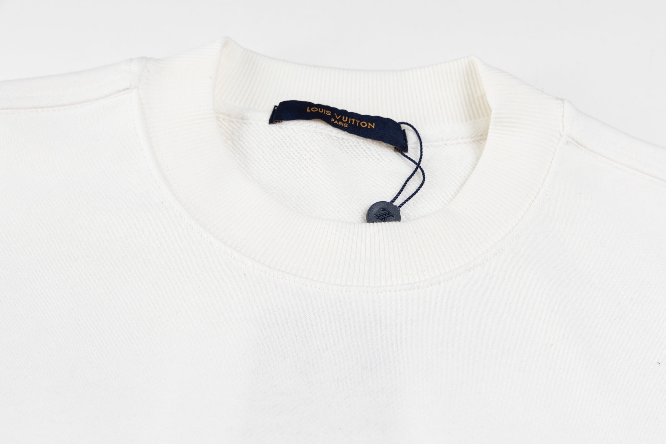White long-sleeve sweatshirt neckline with ribbed collar and neck label