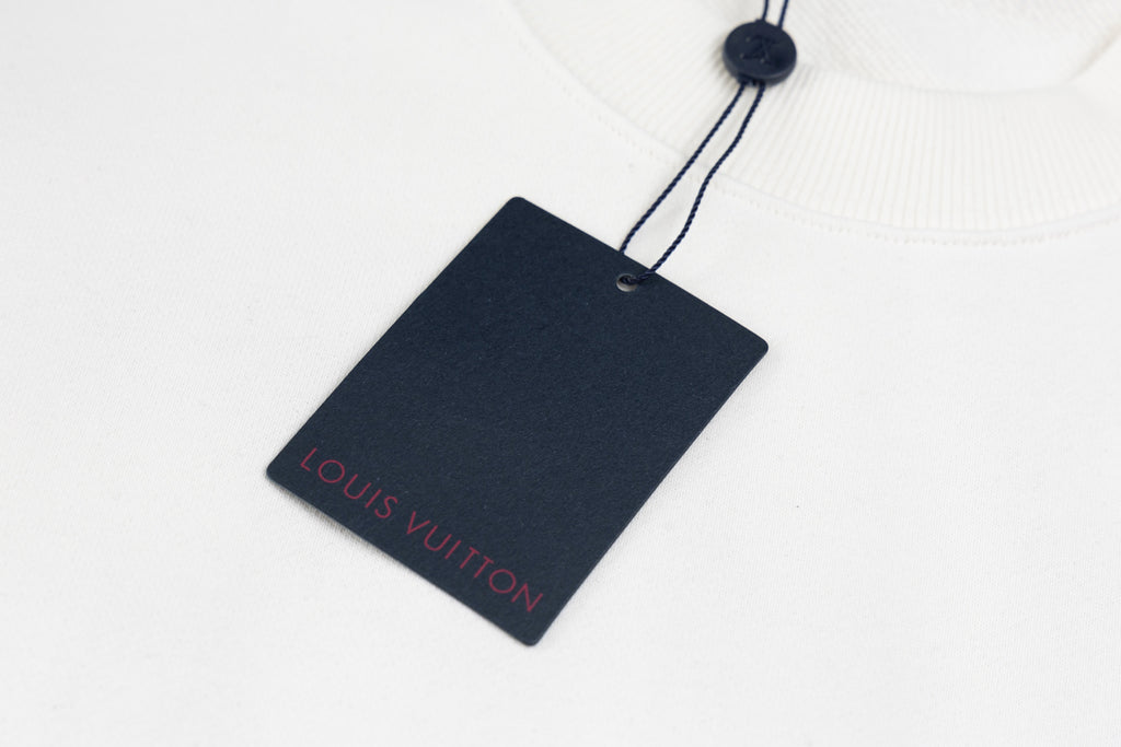 White long-sleeve sweatshirt with Louis Vuitton hang tag tied to neck