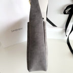 YSL bag, gray tote side view with vertical seam and hanging strap
