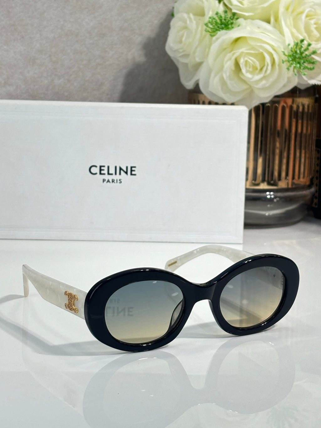 Celine round sunglasses with dark lenses, black frames, and gold logo on temple