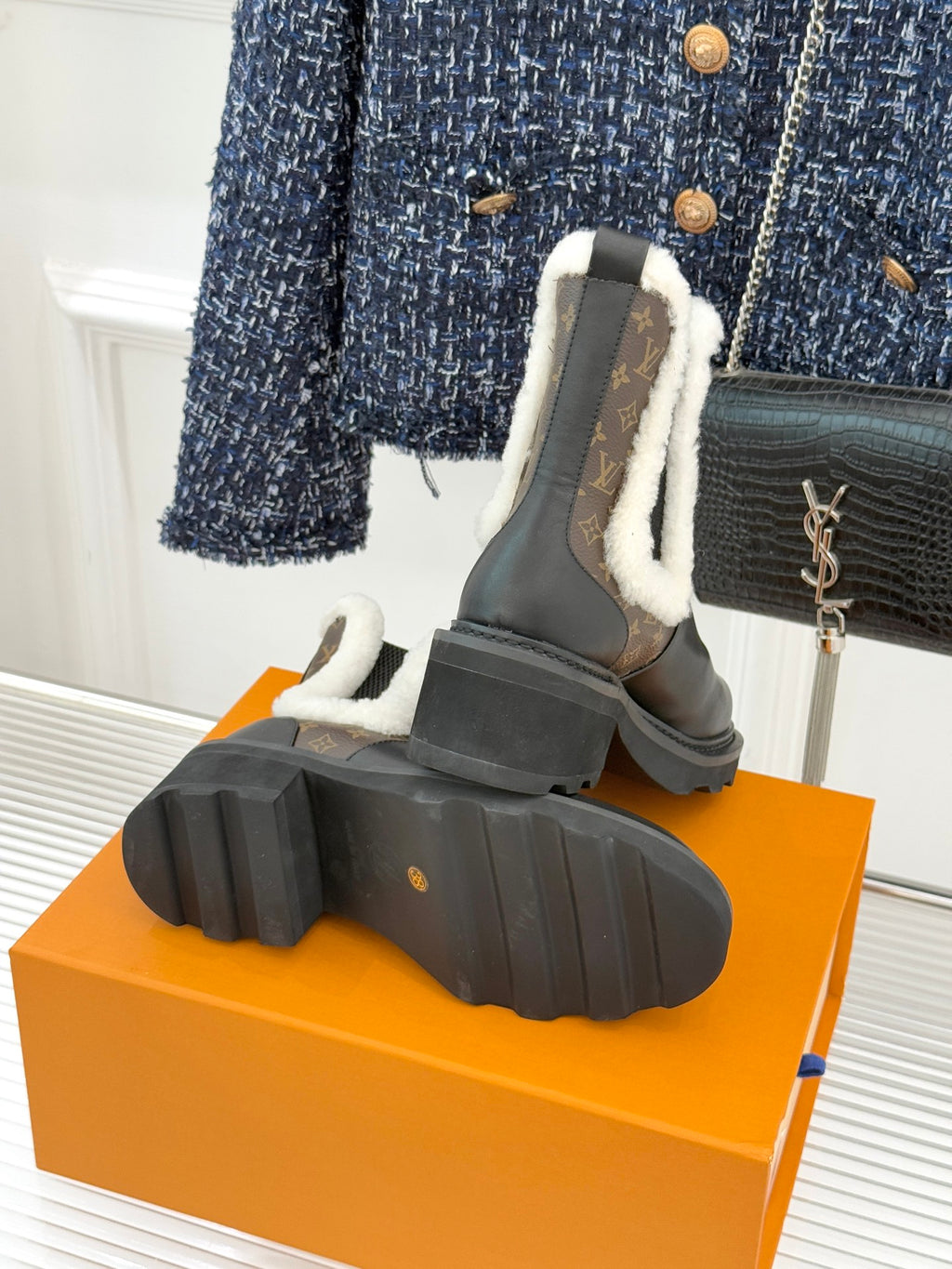 Ankle boot heel view with treaded rubber sole and brown monogram side detail